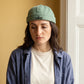 Bonnet docker A Moment orange porté par une femme en intérieur