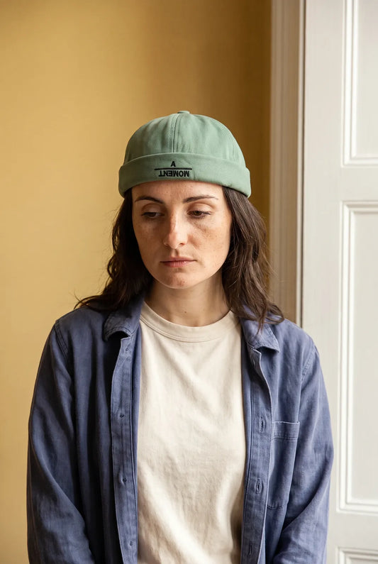 Bonnet docker A Moment orange porté par une femme en intérieur
