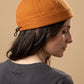 Bonnet docker And orange porté par une femme, vue de dos sur la fermeture