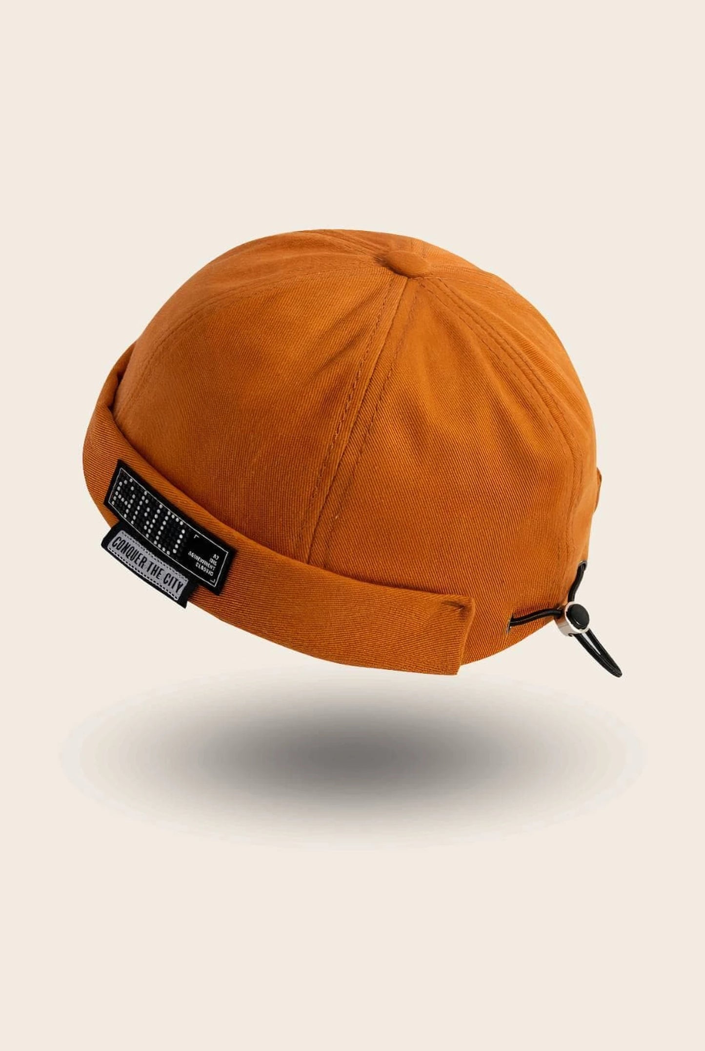 Bonnet docker And orange avec patch Conquer The City, vue de trois quarts arrière