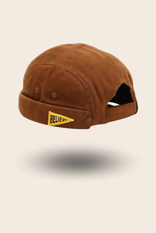 Bonnet docker Believe en velours côtelé marron avec patch brodé Believe, vue de trois quarts arrière