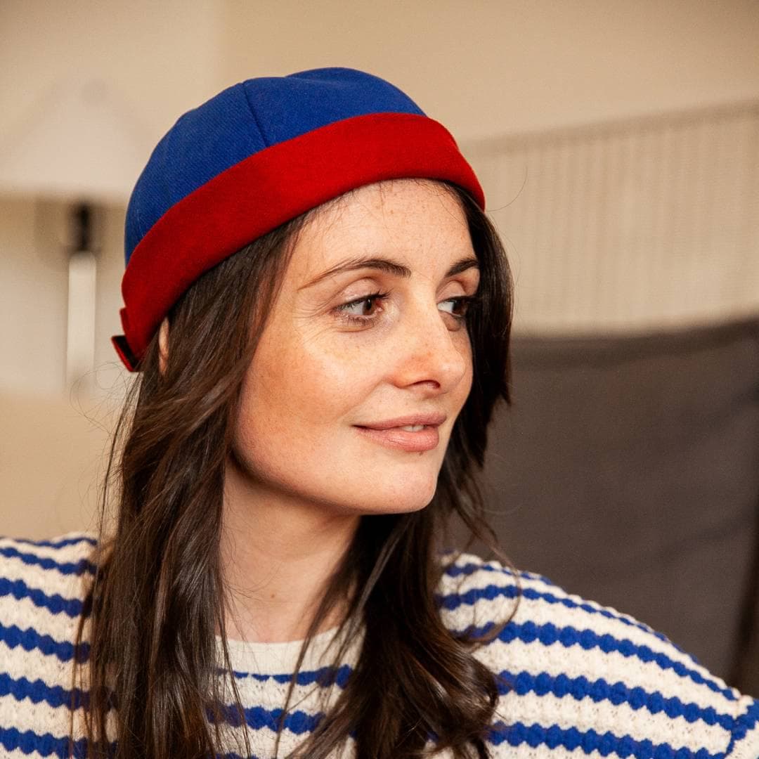 Bonnet docker Bicolore bleu et rouge porté par une femme, vue de trois quarts