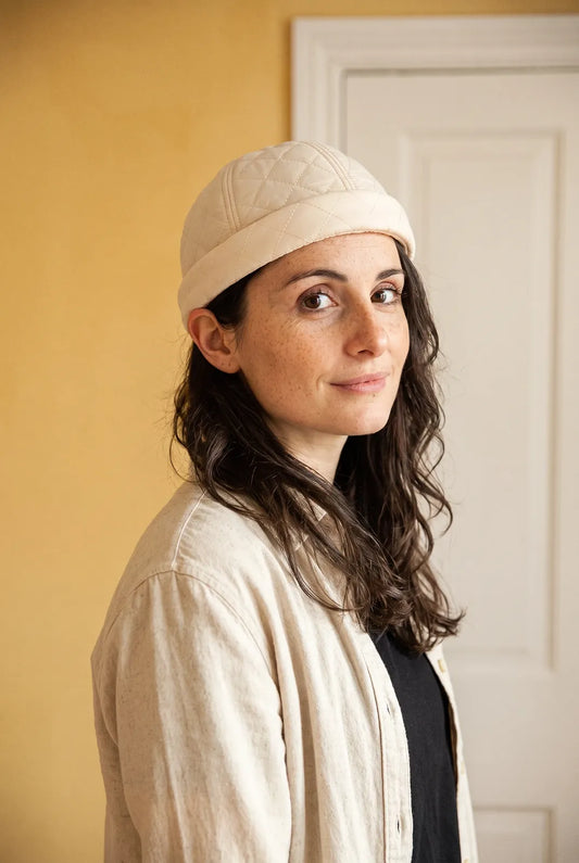 Bonnet docker Cache Oreille crème porté par une femme en intérieur