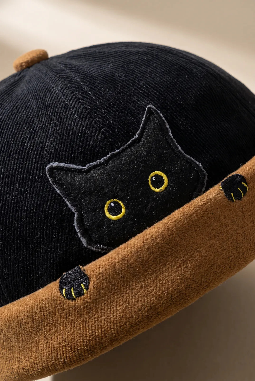 Gros plan sur la matière du bonnet docker Chat noir & camel