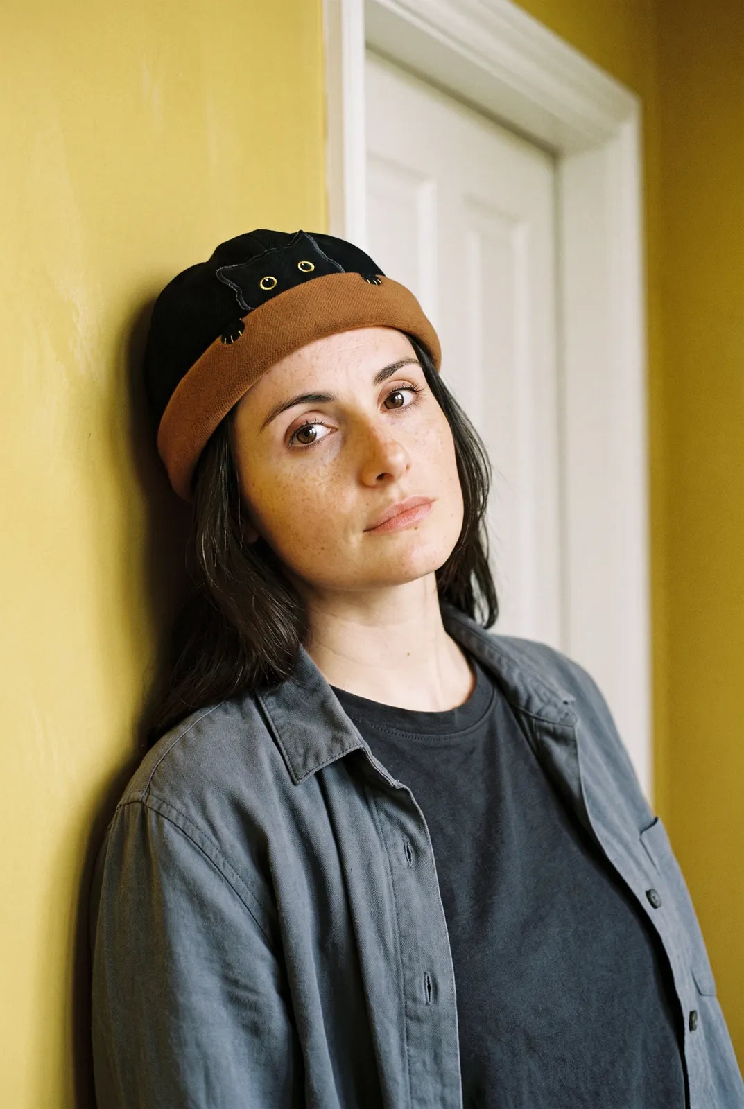 Bonnet docker Chat noir & camel porté par une femme en intérieur