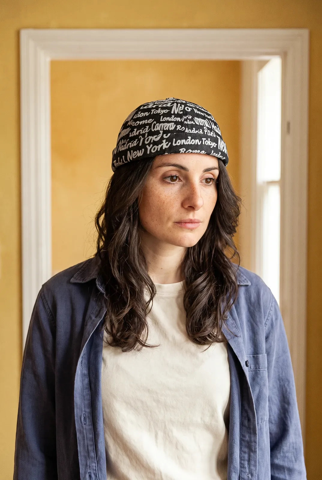 Bonnet docker Cosmopolitain noir porté par une femme en intérieur