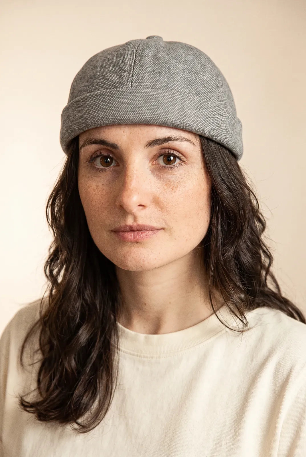 Bonnet docker Coton Piqué gris chiné clair porté par une femme, portrait