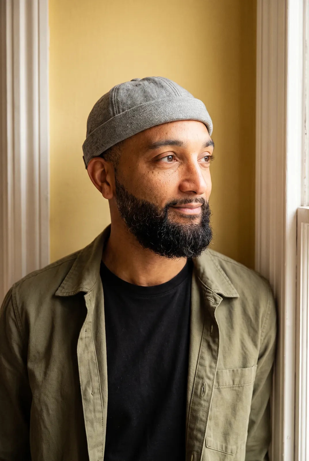 Bonnet docker Coton Piqué gris chiné clair porté par un homme en intérieur