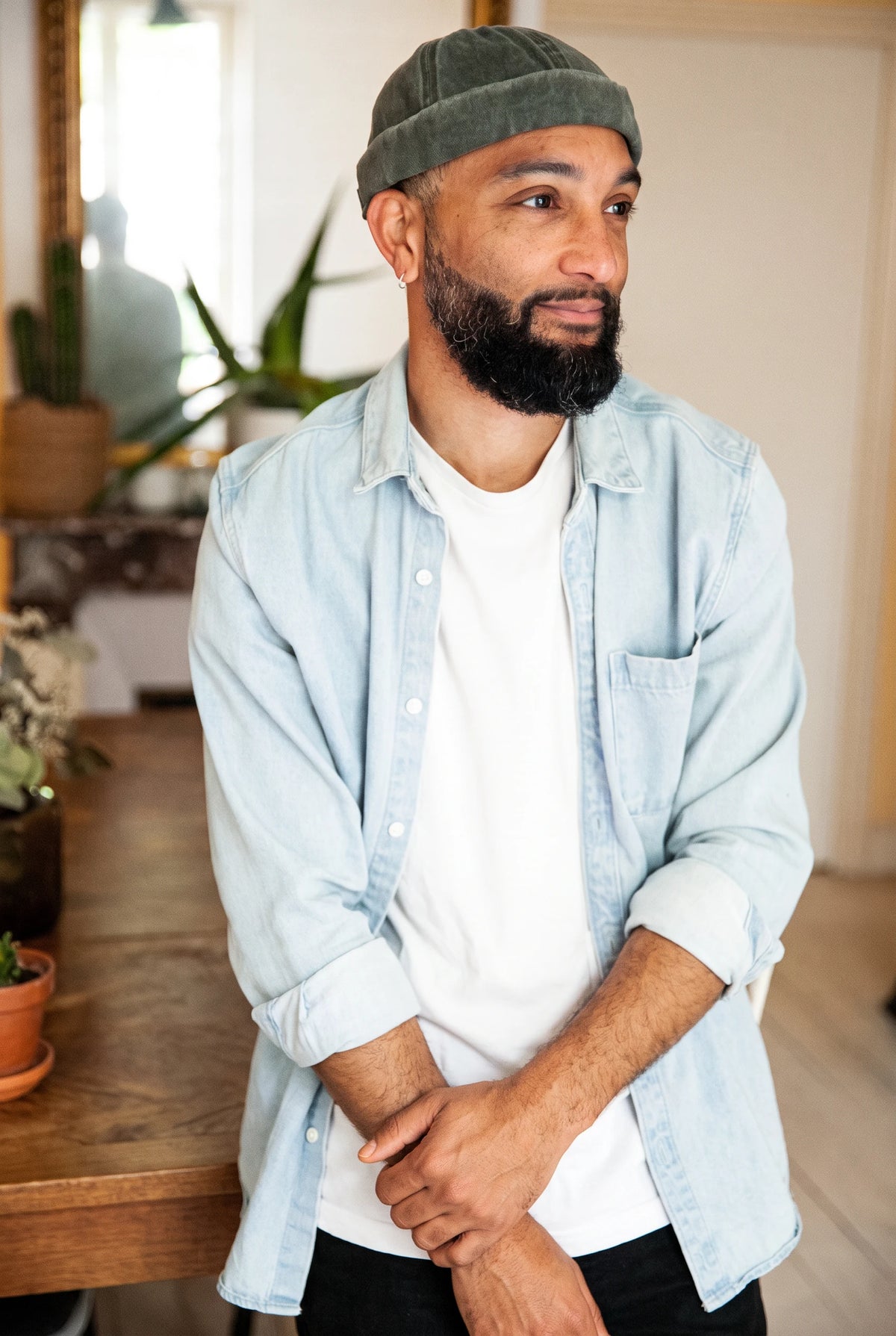 Bonnet docker en coton kaki porté par un homme, intérieur avec plantes