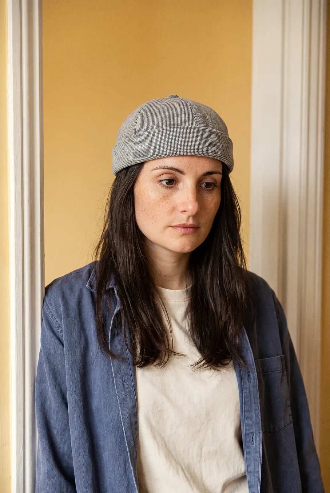 Bonnet docker Design gris porté par une femme en intérieur