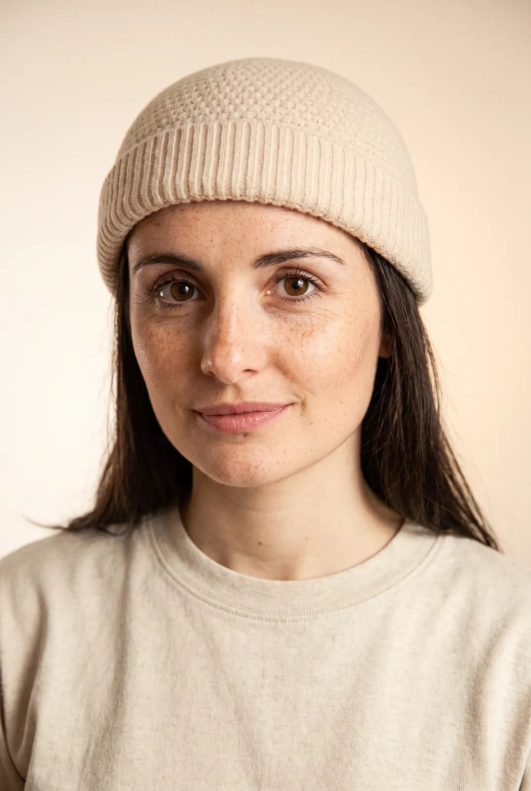 Bonnet docker Grosse Maille beige porté par une femme, portrait