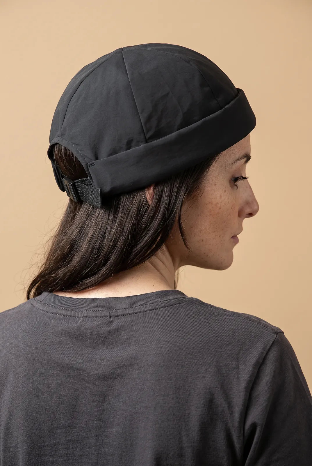 Bonnet docker Imperméable vert militaire porté par une femme, vue de dos sur la fermeture