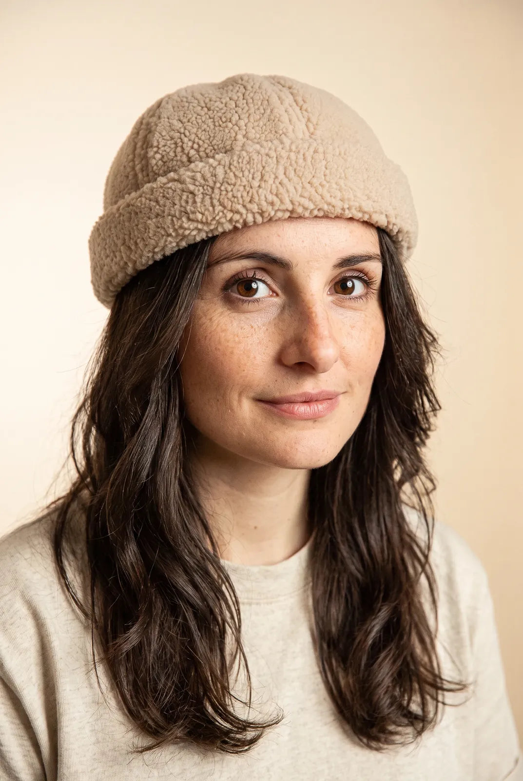 Bonnet docker Mouton retourné beige porté par une femme, portrait