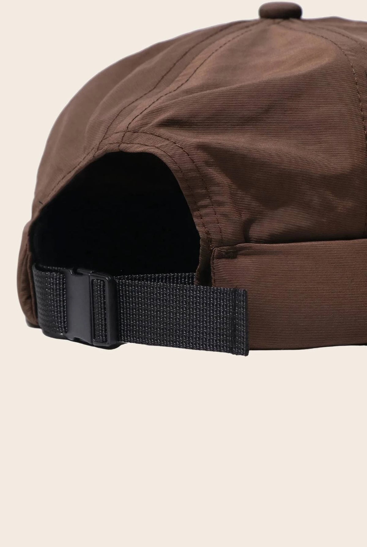 Gros plan sur la fermeture réglable du bonnet docker Nylon marron