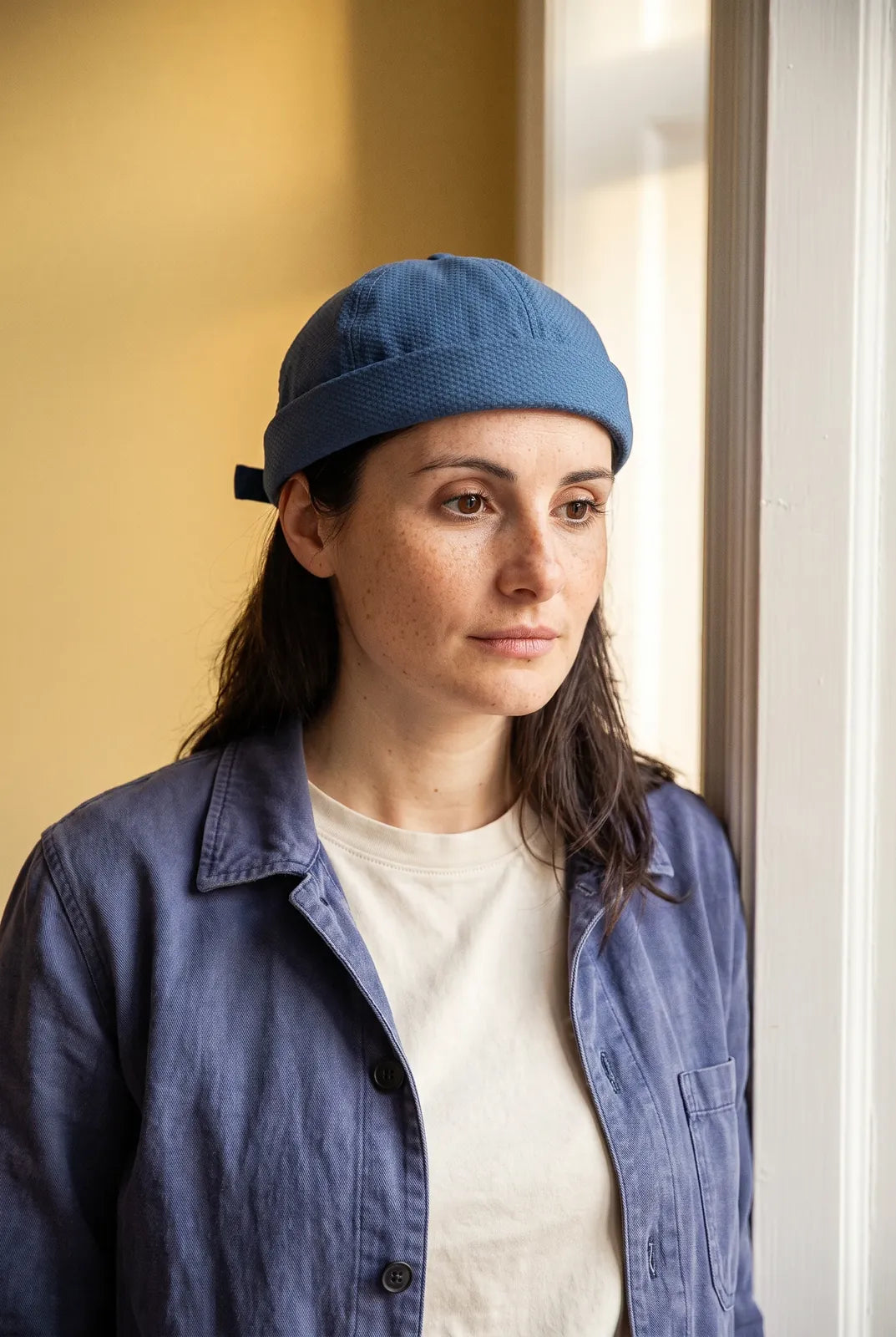 Bonnet docker Original en Coton vert foncé porté par une femme en intérieur