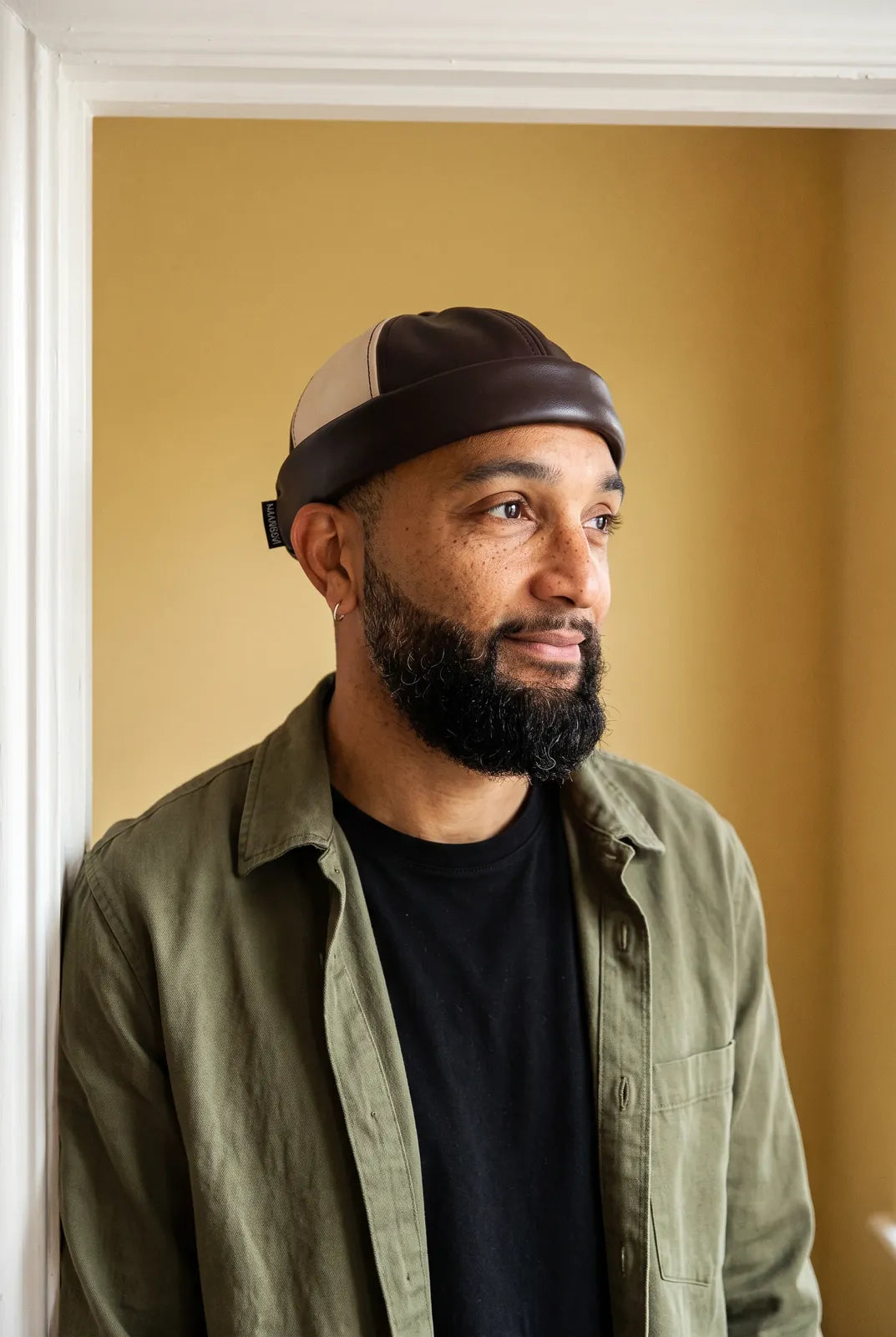 Bonnet docker Rétro noir & camel porté par un homme en intérieur