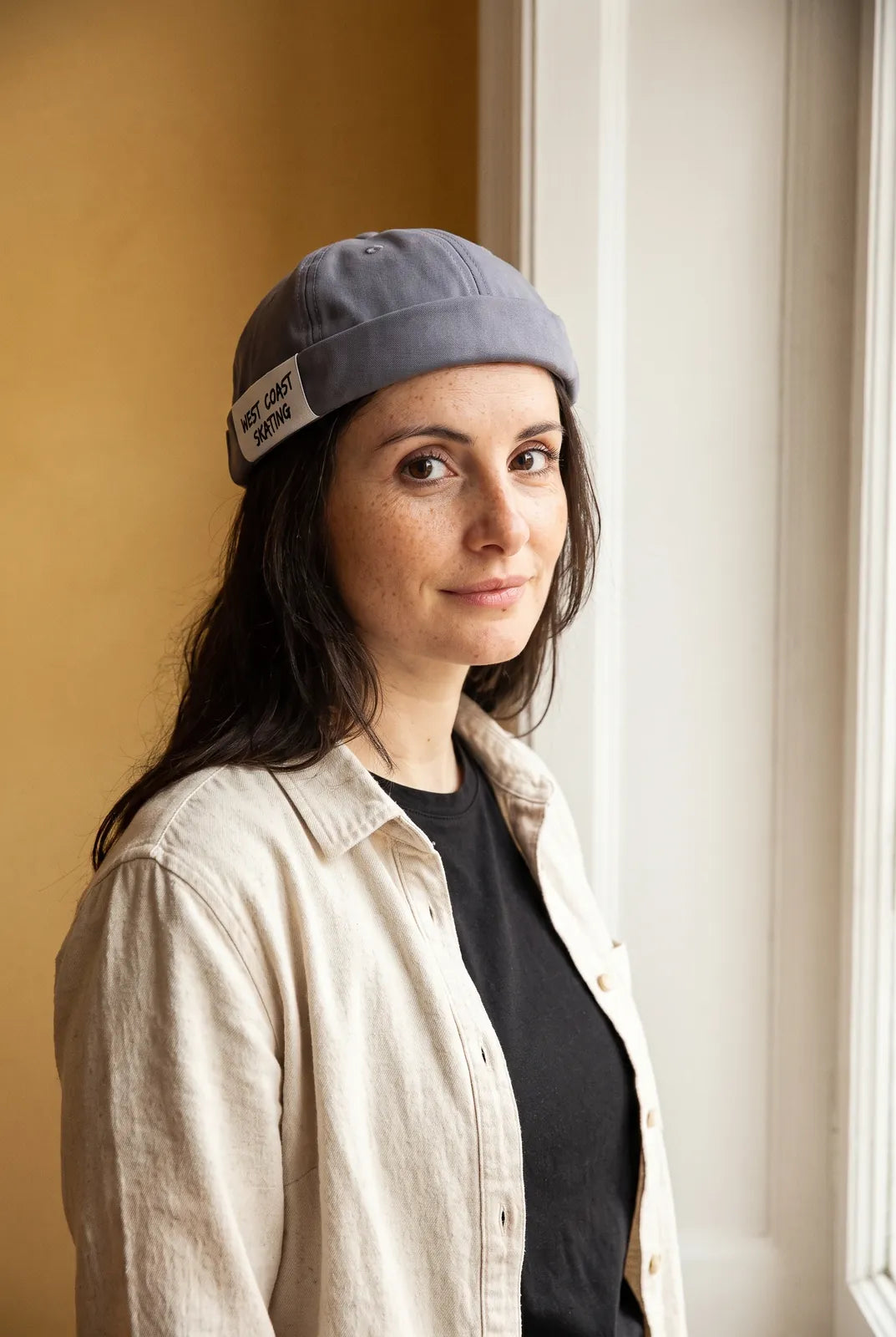Bonnet docker Skate gris porté par une femme en intérieur
