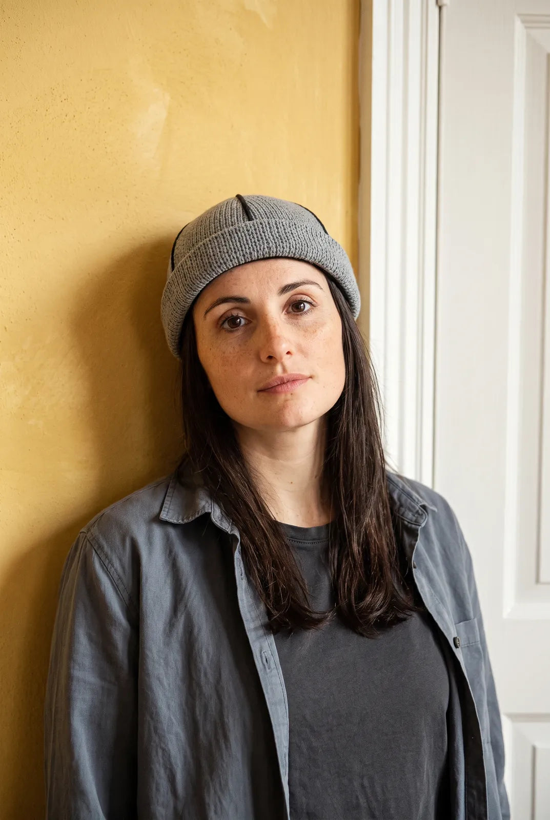 Bonnet docker Tricot bleu marine porté par une femme en intérieur