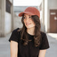 Casquette velour côtelé terracotta portée par une femme en extérieur